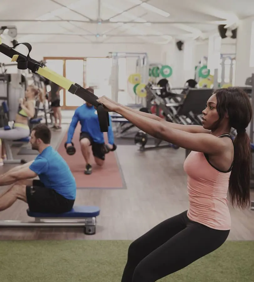 Woman working out with suspension trx in gym