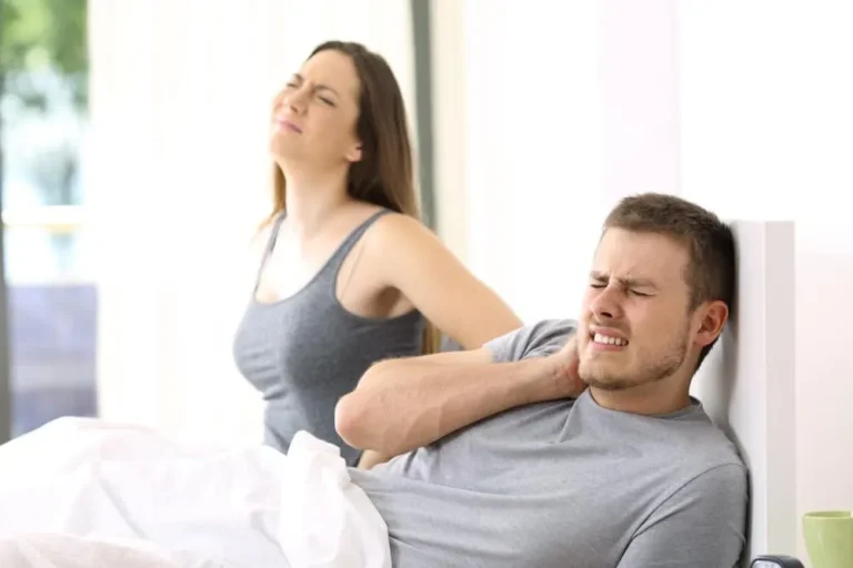couple in bed with pains in neck and back