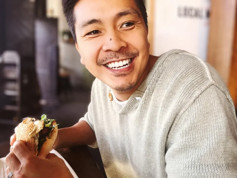 man smiles whilst holding food