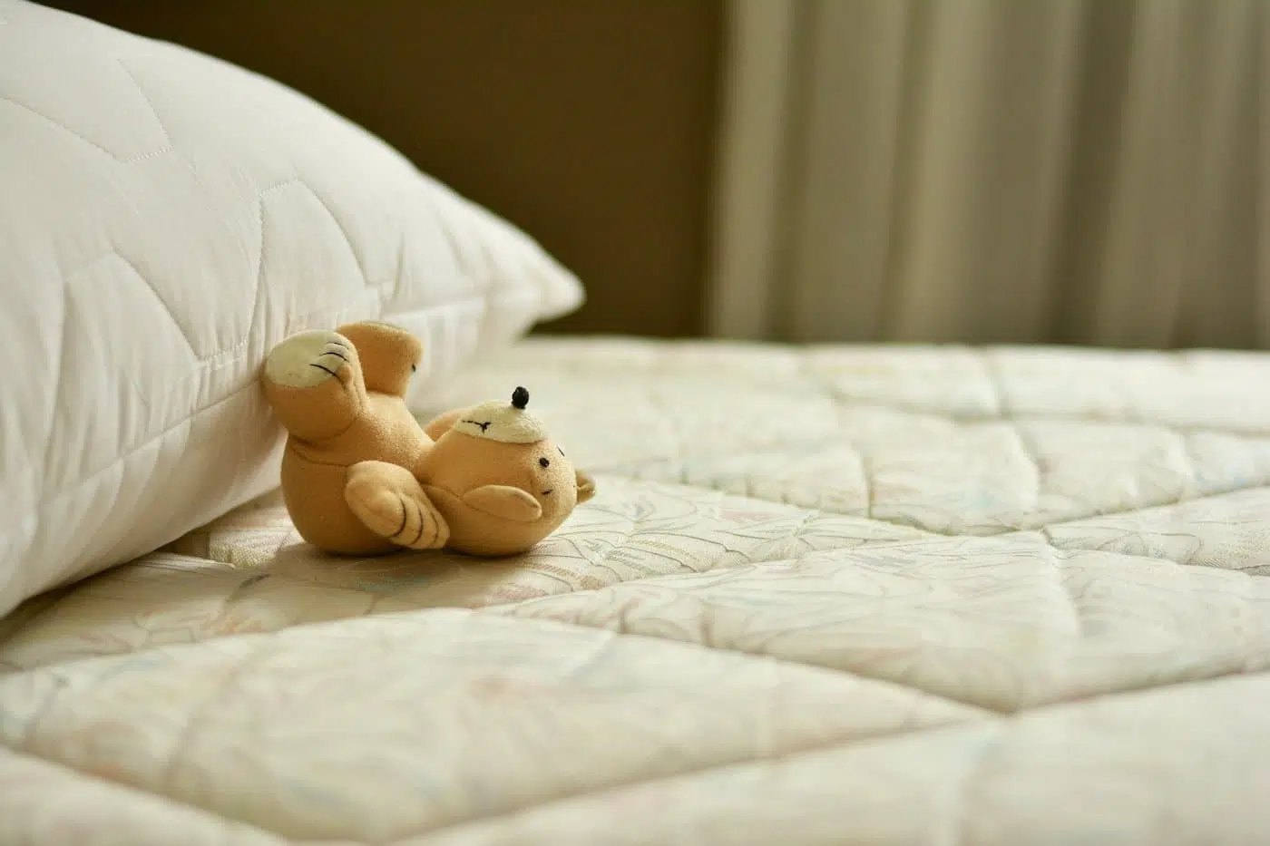 Small teddy bear on mattress
