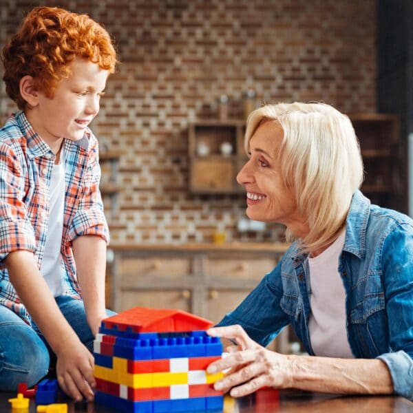 woman smiles at child over lego bricks scaled