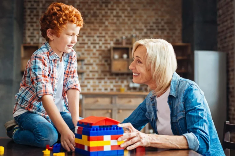 woman smiles at child over lego bricks scaled