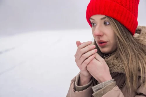 woman warms hands e1629016786617