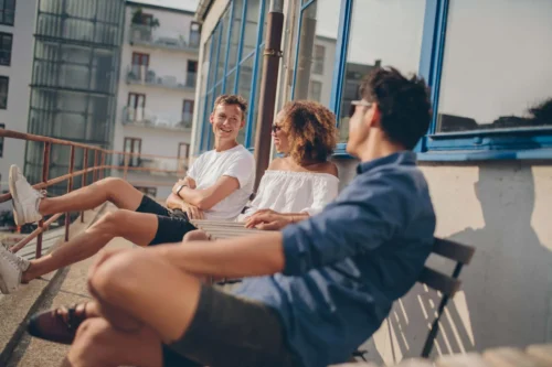 young people on bench share a joke scaled