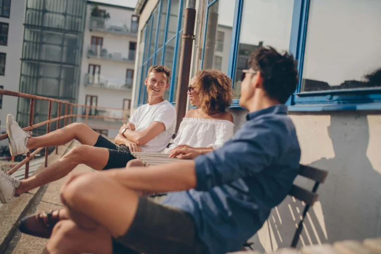 young people on bench share a joke scaled