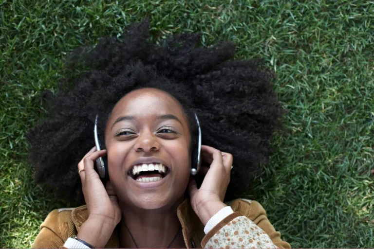 young woman laughs listening to her headphones