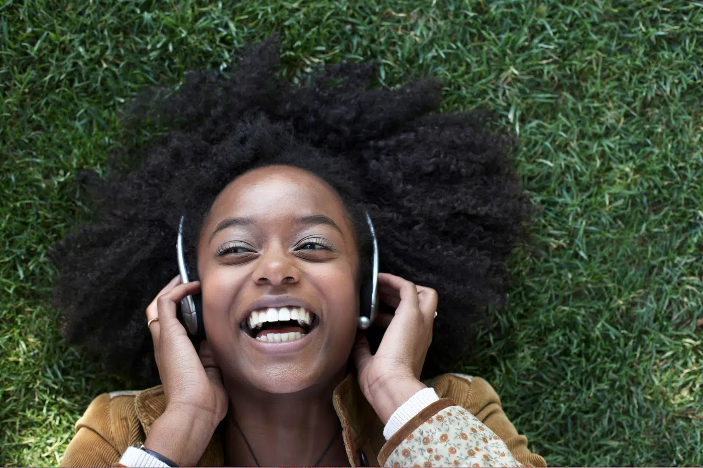 Young woman laughs listening to her headphones