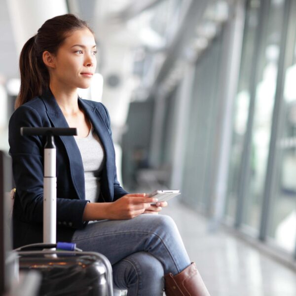 young woman sits at airport scaled e1629366858854
