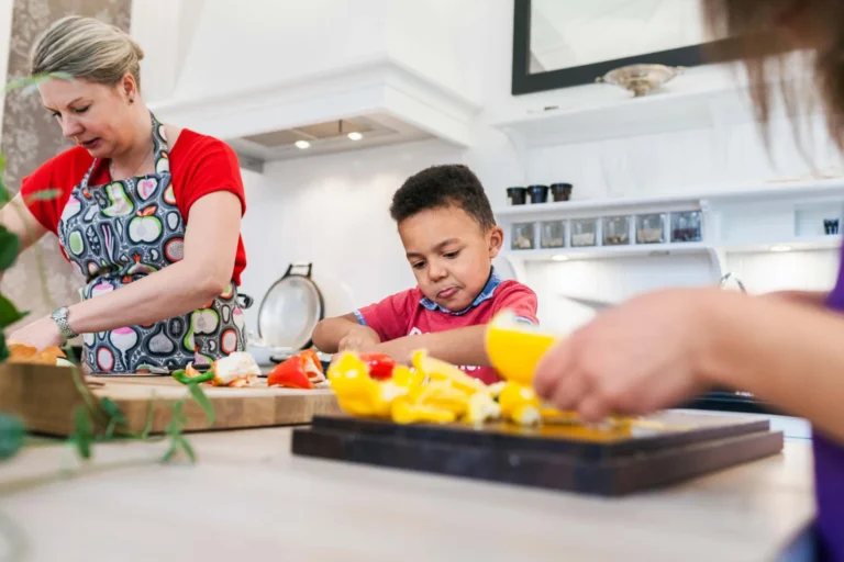child prepares food with mum in kitchen scaled