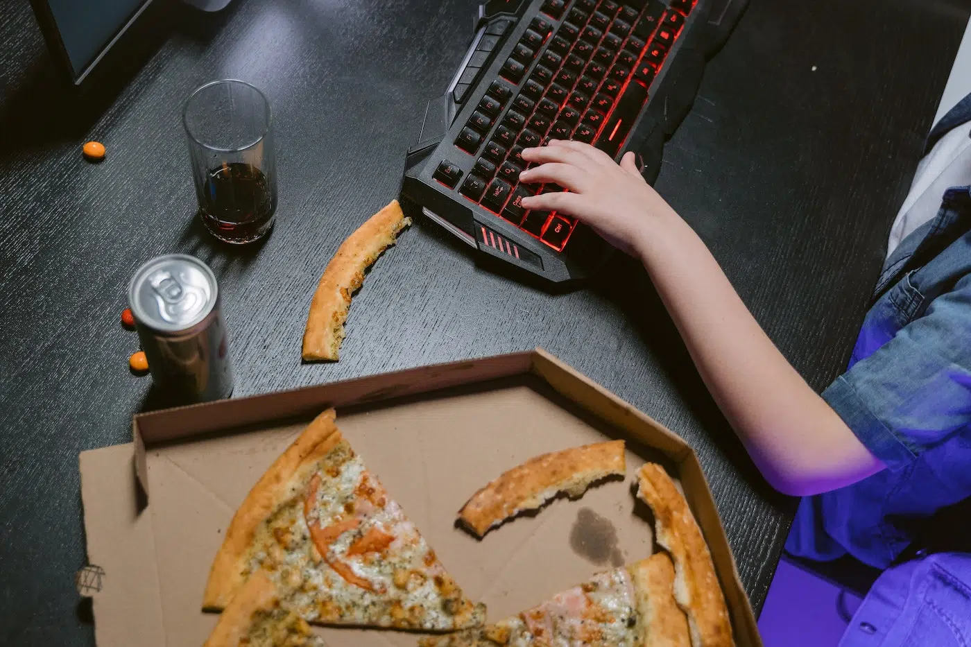 Gamer with pizza on desk