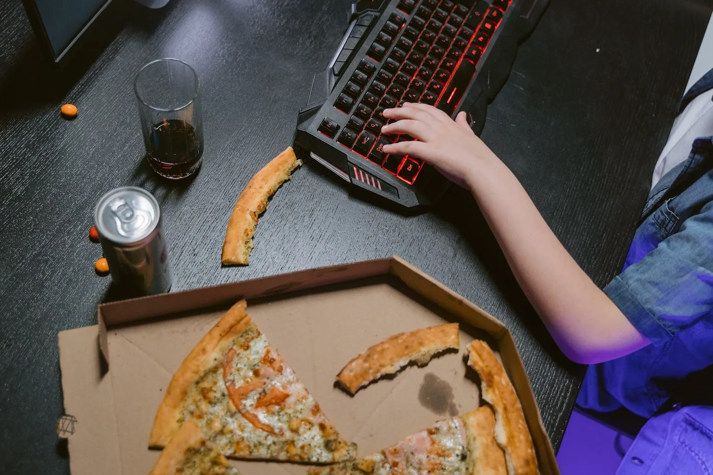 gamer with pizza on desk