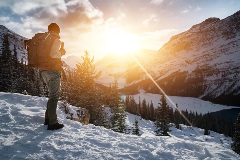 mountain hiker looks out over snowy mountains