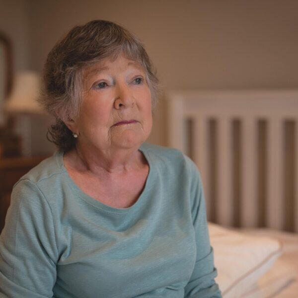 older lady looking sad on bed