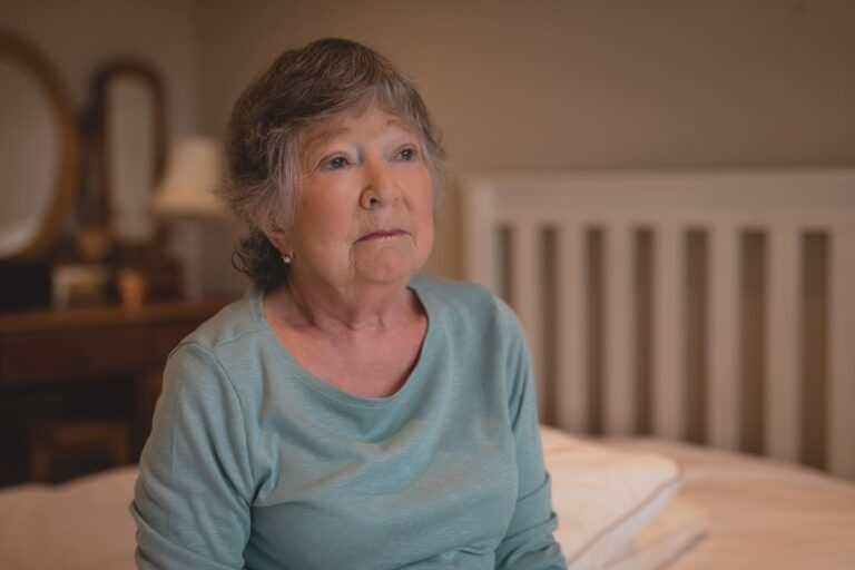 older lady looking sad on bed