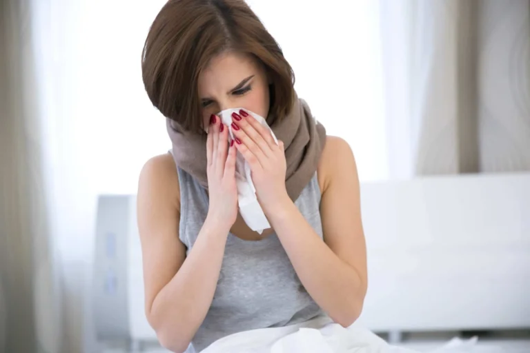 woman blows nose into tissue scaled