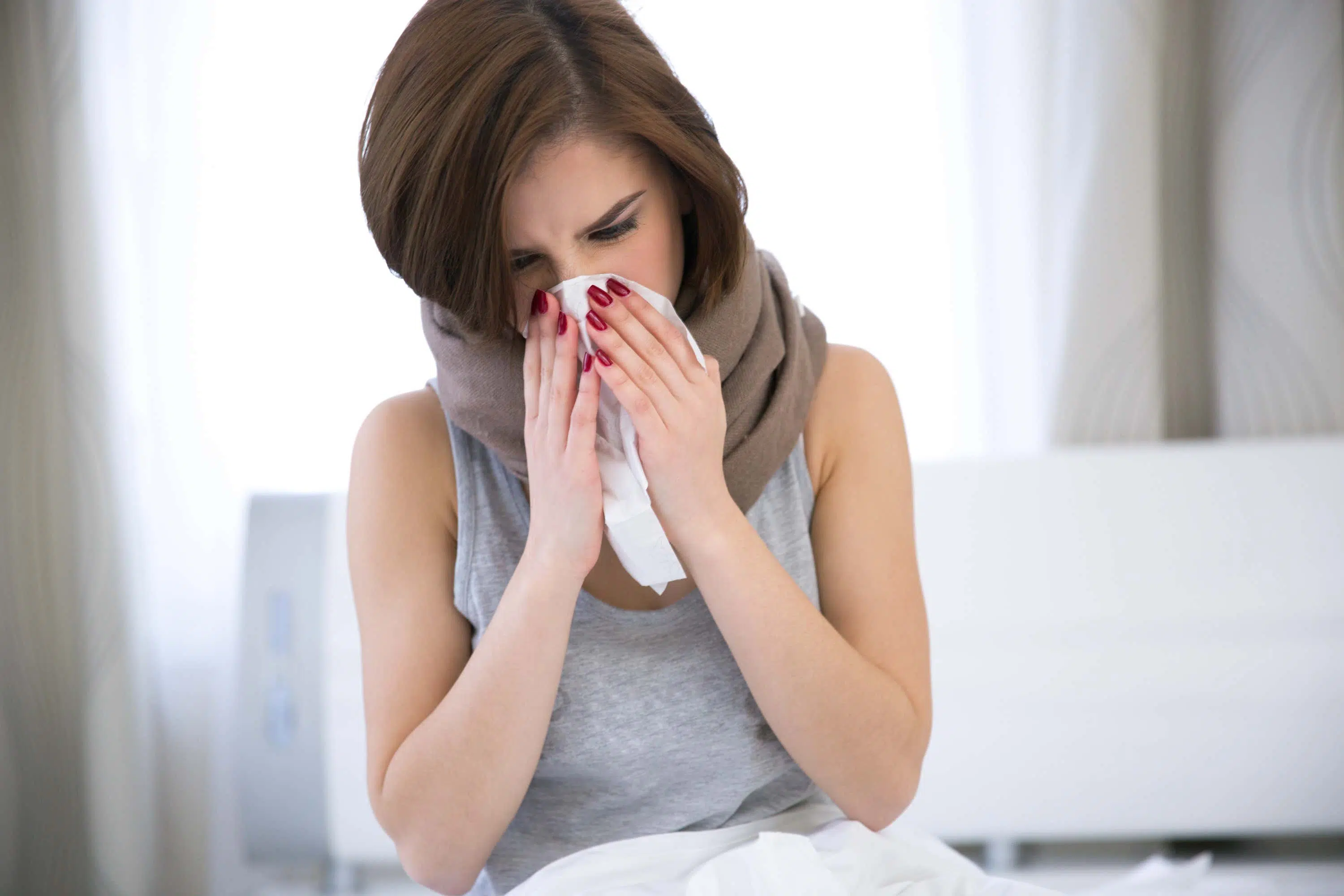 Woman blows nose into tissue scaled