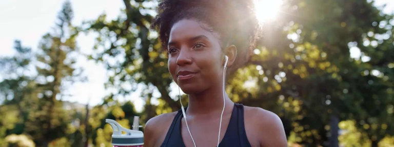 woman holds water bottle in park