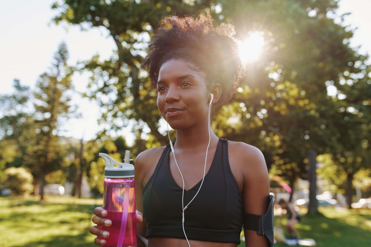 Tackling Your First Half-Marathon? Beyond A Training Plan, These Are A Few Important Tips To Keep In Mind 2 Woman holds water bottle in park