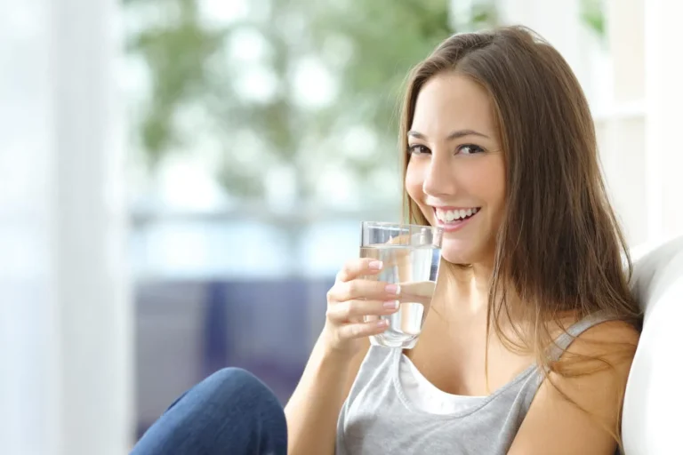 woman smiles drinking water