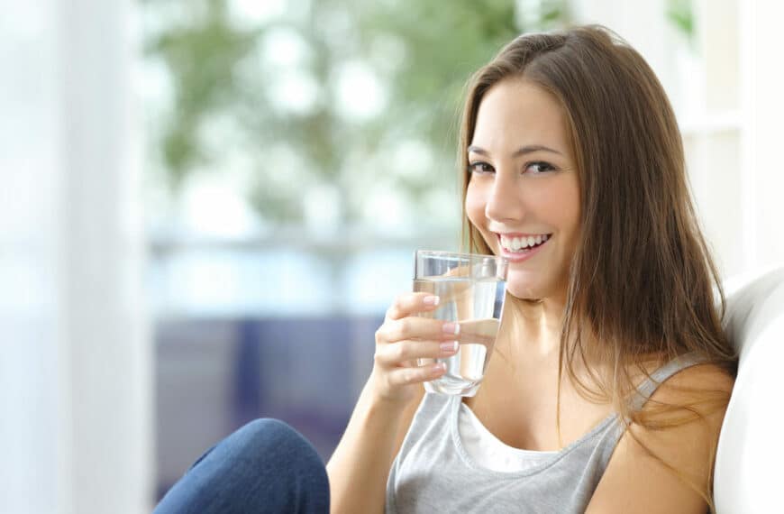 woman smiles drinking water