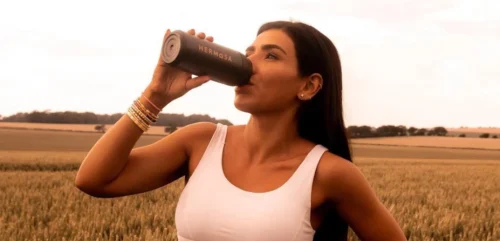 woman using hermosa bottle e1655204694303