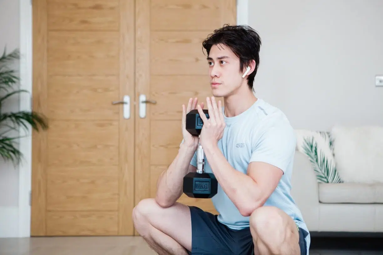 Young man uses dumbell for exercise
