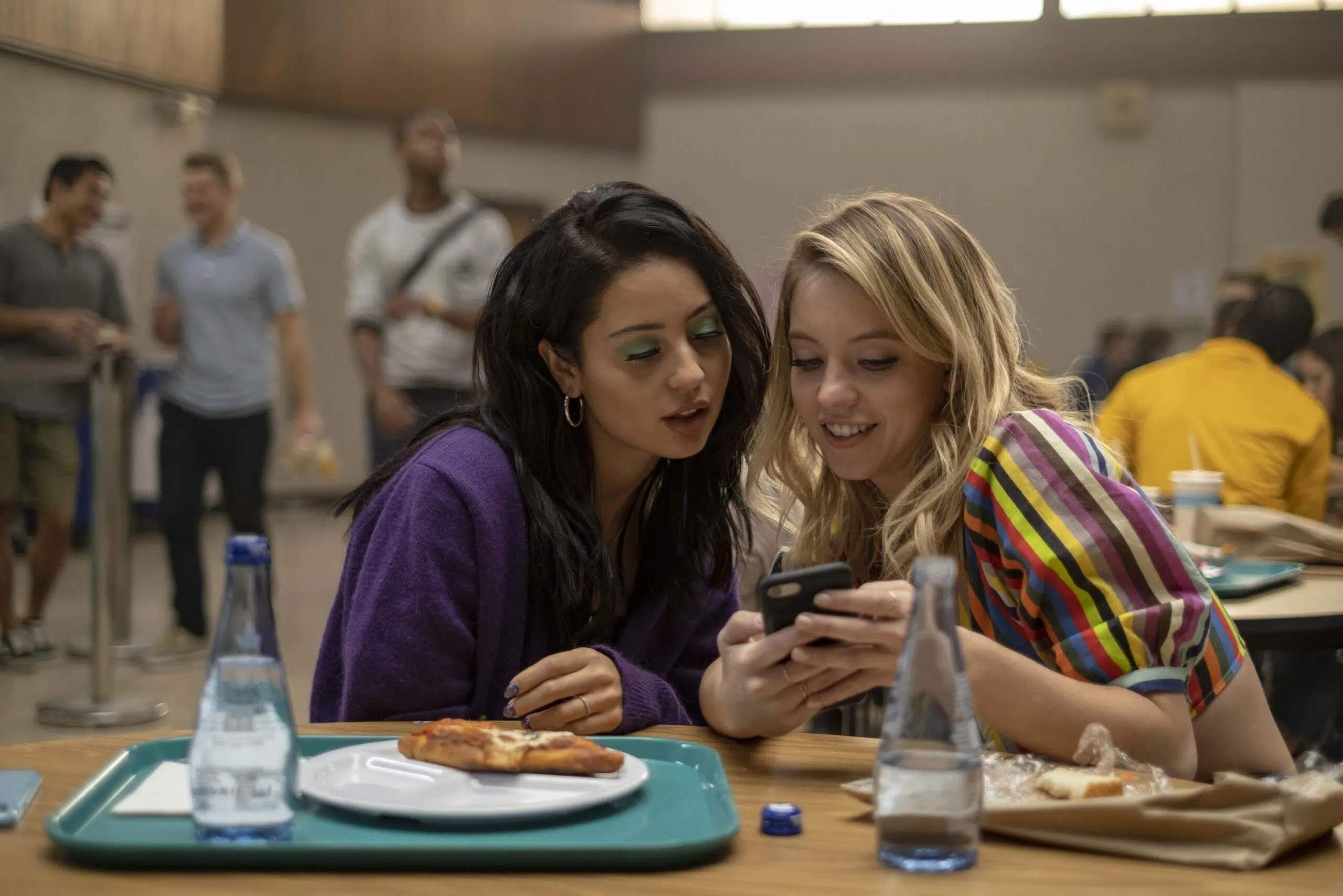 Young women look at mobile phone scaled