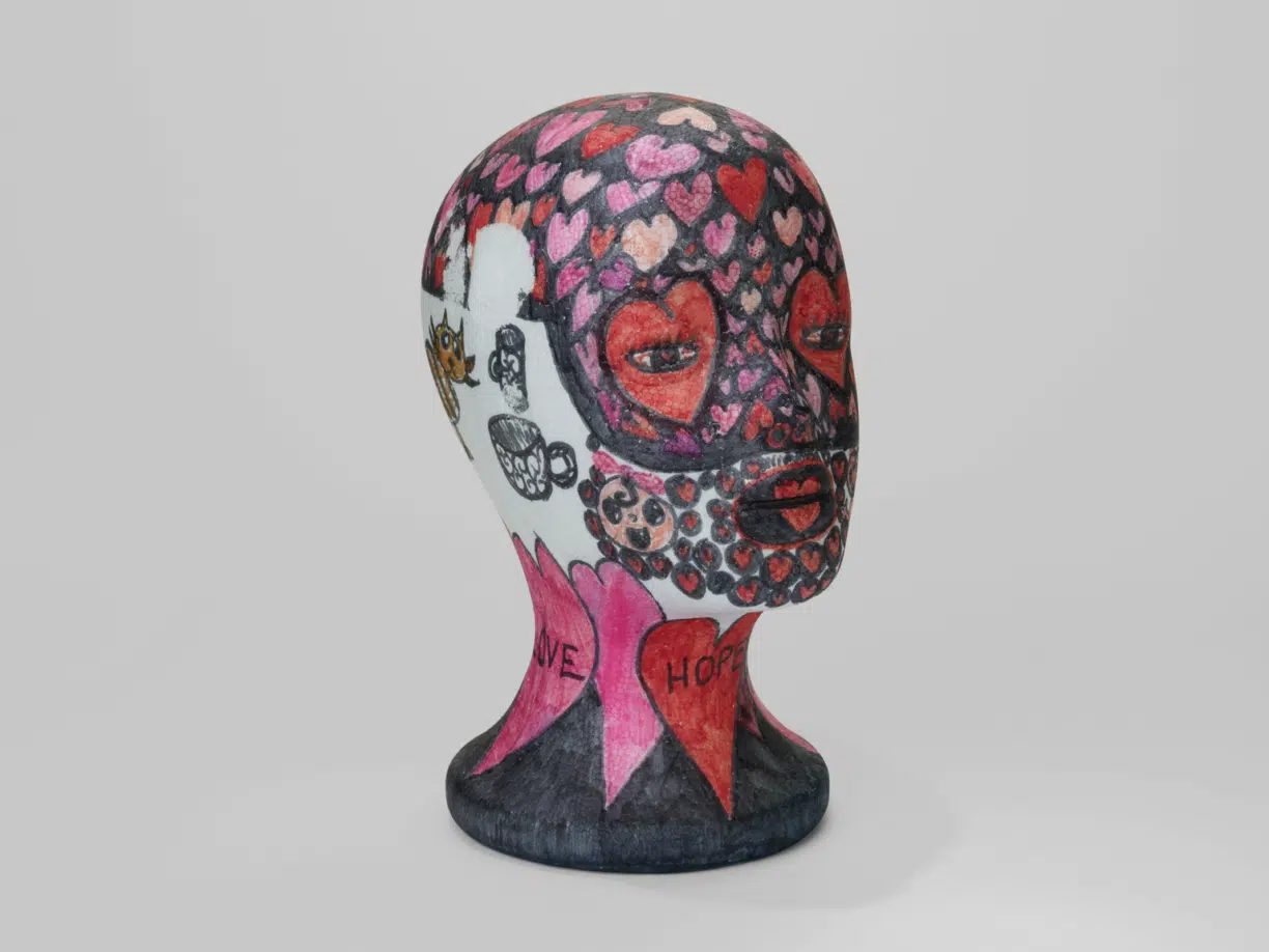 Sarah herds decorated wig stand from the exhibitions cancer collection project