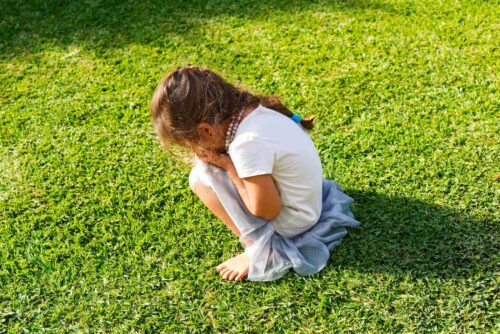 child crouches on floor