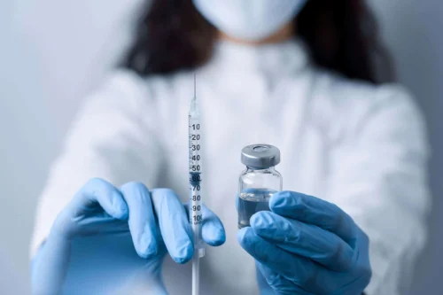 dr holds covid vaccine scaled