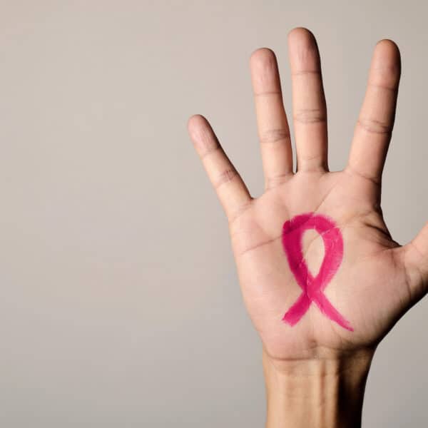 hand with pink ribbon on