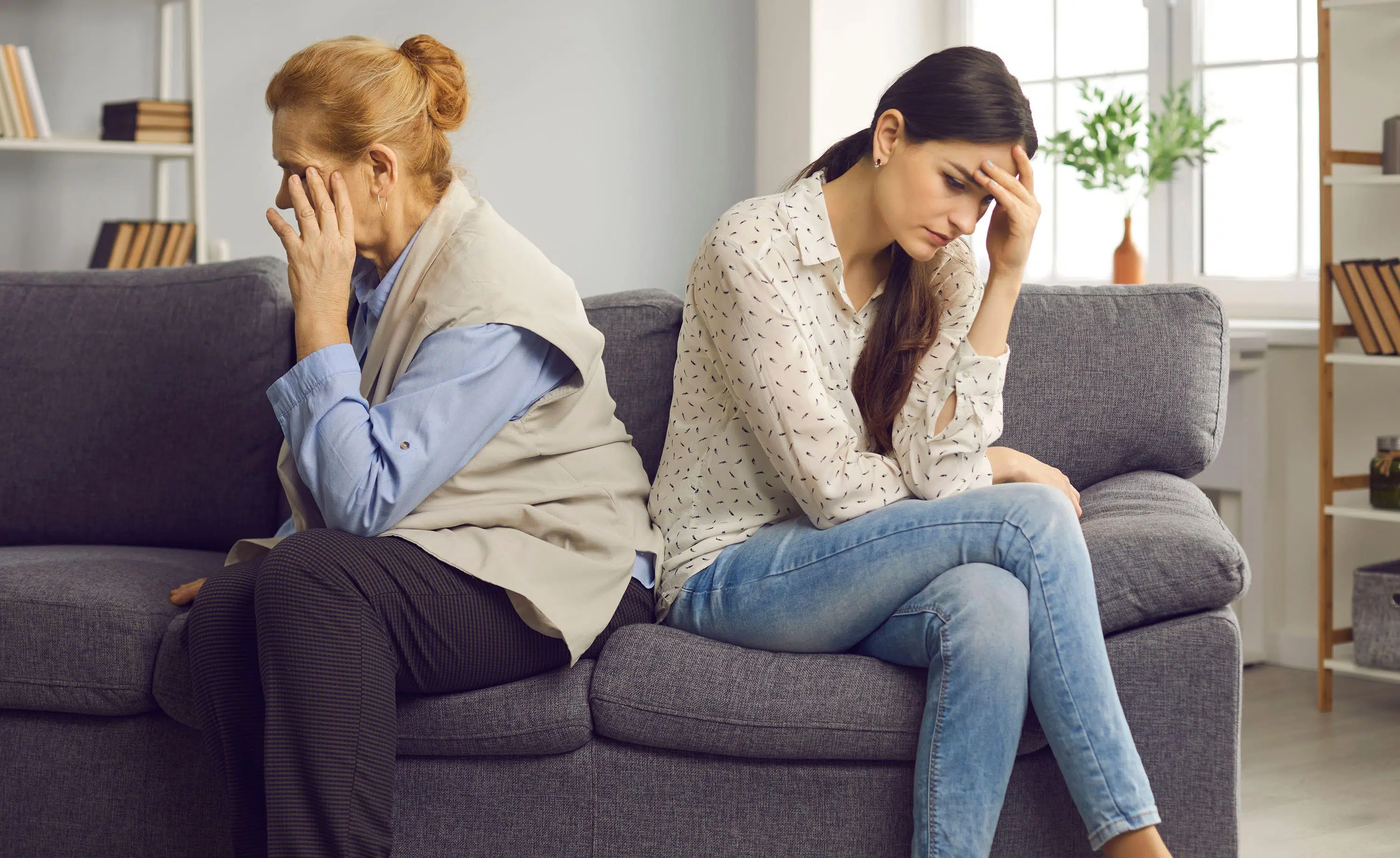 Mum and daughter sit looking away from each other scaled