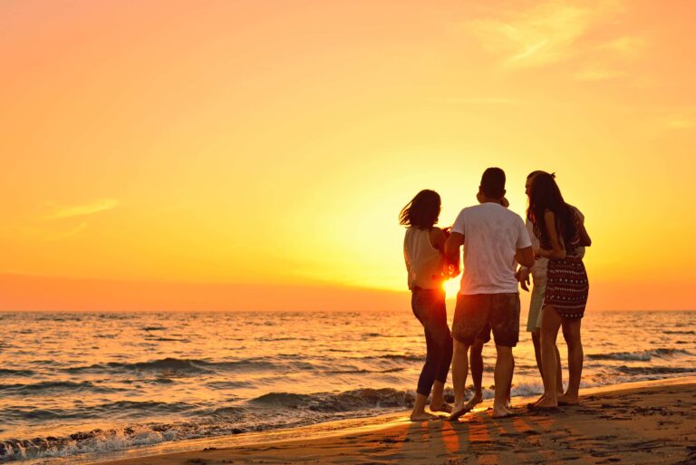 people on a beach during sunset