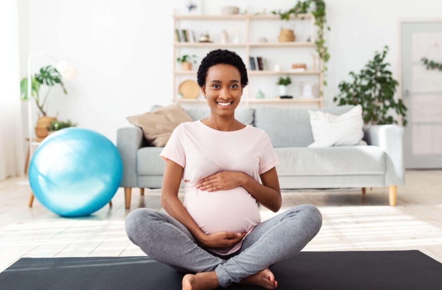 pregnant woman sits feeling stomach scaled