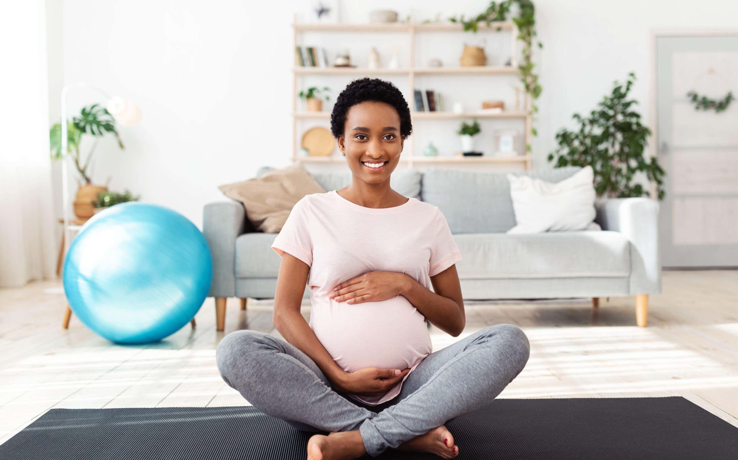 pregnant woman sits feeling stomach scaled