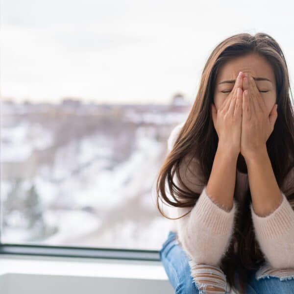 woman covers face with hands scaled