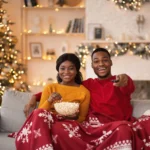 couple laugh wearing christmas pyjamas scaled
