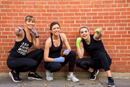 women fitness lovers squat by wall