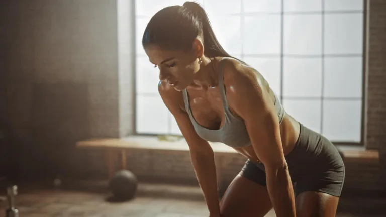 Strong Fit Brunette Wiping Sweat from Her Face in a Loft Industrial Gym with Motivational