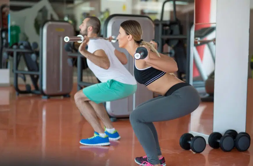 fitness couple perform squats scaled