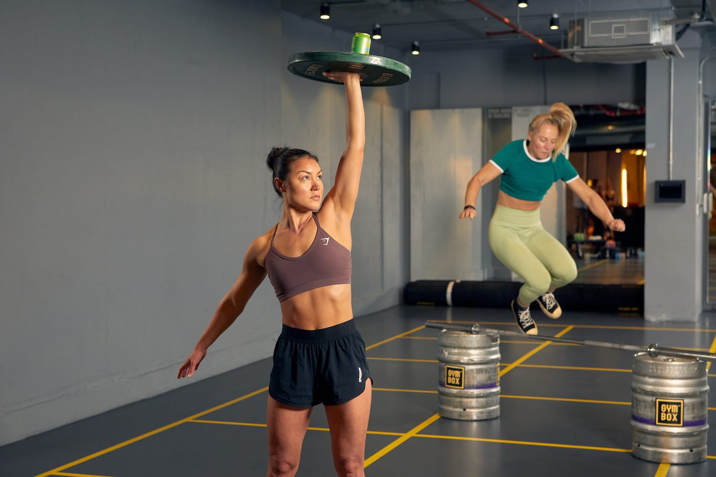 gymbox trainer lifts weight above head
