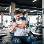 man holds injured shoulder