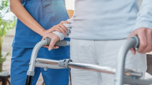 nurse helping woman to walk