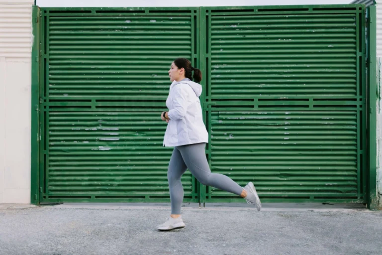 person running against green shutter scaled