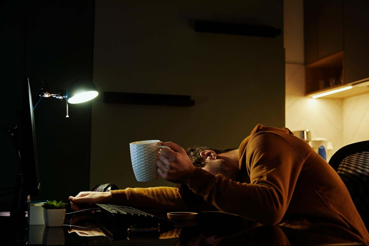 person slumped at table with burnout