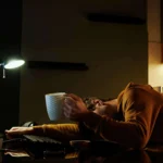 person slumped at table with burnout