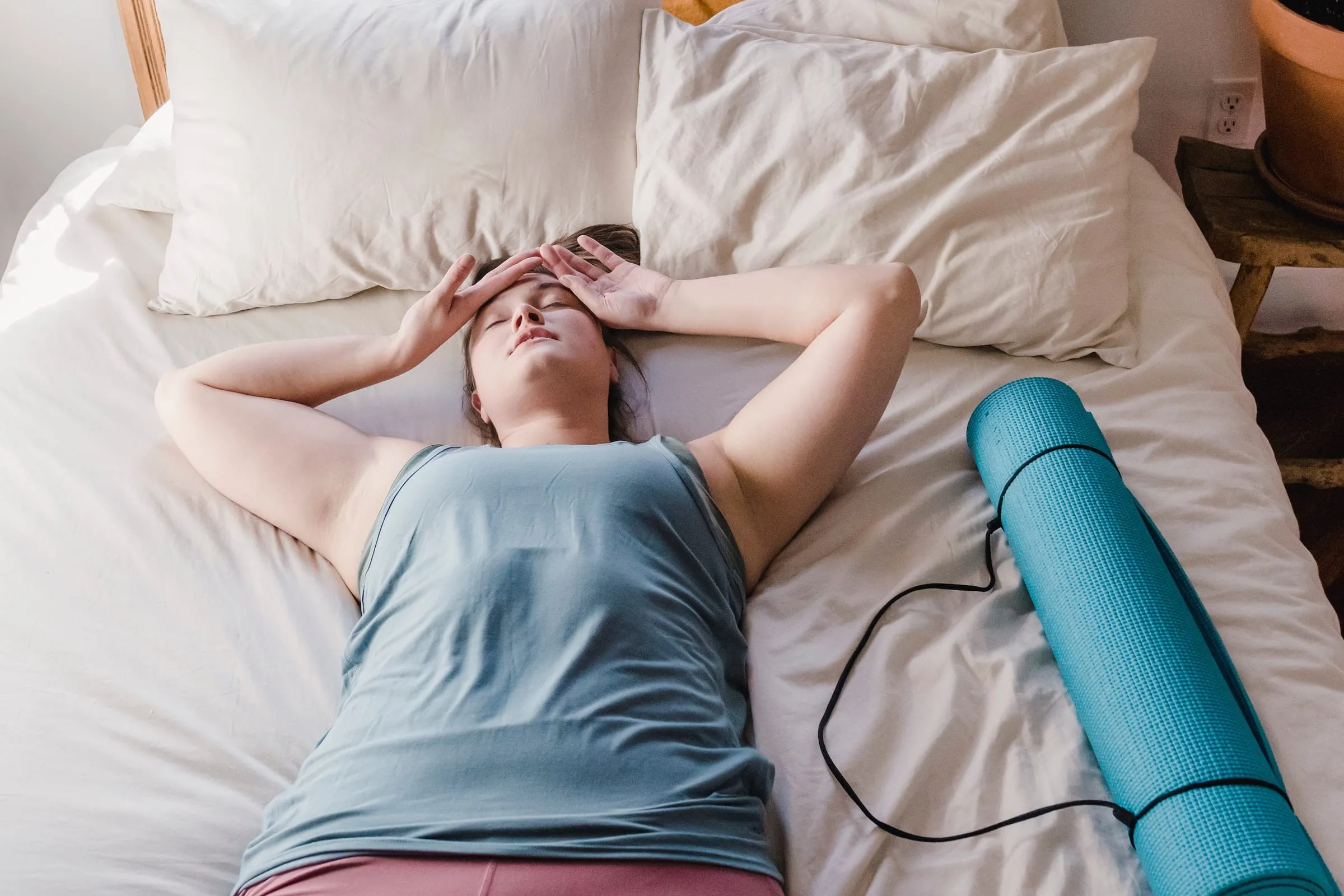 woman lays out flat on top of bed