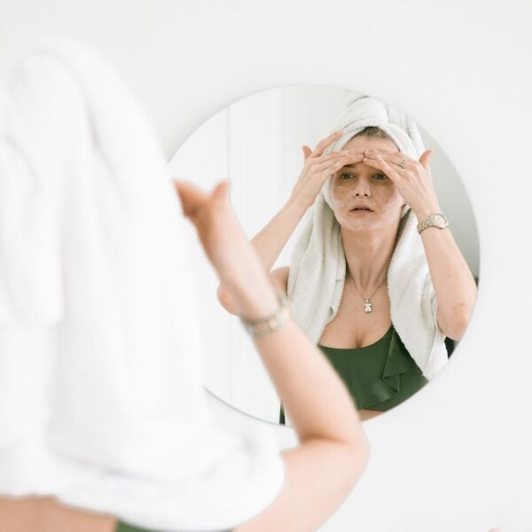 woman looking after skin in mirror