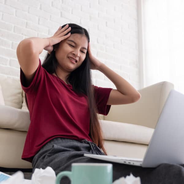 woman looking stressed out looking at her laptop