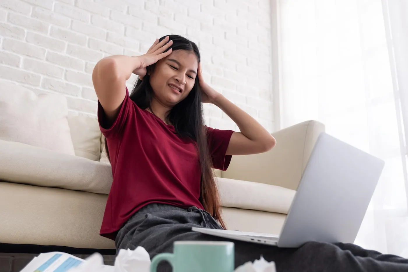 woman looking stressed out looking at her laptop